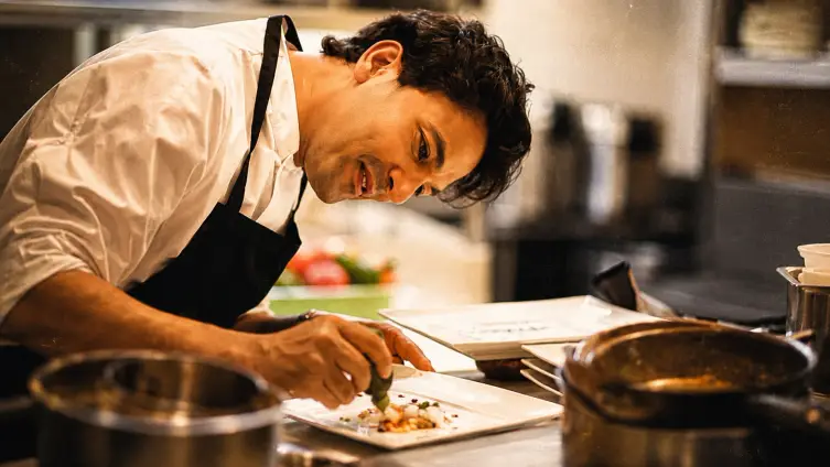 Food creator plating a dish in the kitchen