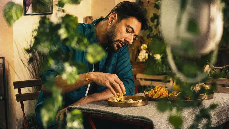 Food stylist arranging a spread by warm light
