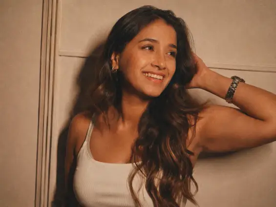 Creator smiling against a warm-lit wall